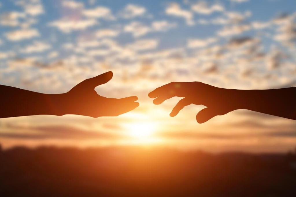 Two hands reaching toward each other with sunrise in the background.